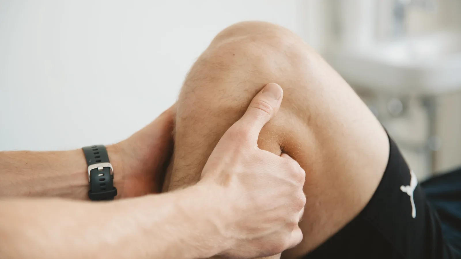 Close de terapia manual no joelho durante sessão de fisioterapia